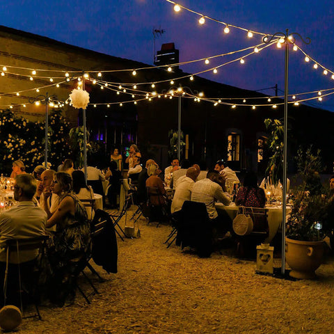 Outdoor wedding scene with Heavy Duty Outdoor String Light Poles 9 Ft Two Pack For Backyard Patio Lights, creating bistro vibe.