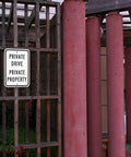 Heavy Duty Reflective Aluminum Sign For Private Drives And Home Grounds Tough As Nails Weatherproof Outdoor Marker on a wooden fence.