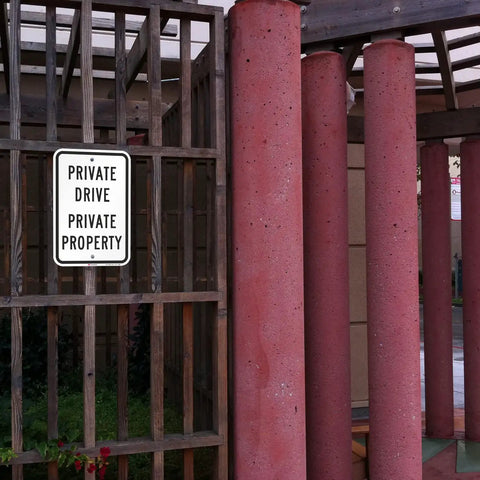 Heavy Duty Reflective Aluminum Sign For Private Drives And Home Grounds Tough As Nails Weatherproof Outdoor Marker on a wooden fence.