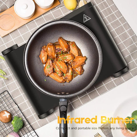 Top view of a Portable 1200W Infrared Electric Stove With Quick Heat 7 Inch Ceramic Glass Burner, cooking chicken wings in a pan.