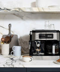 All In One Coffee And Espresso Maker With Dual Heating So You Can Brew Fast And Get Barista Grade Espresso 15 Bar Italian Pump Delivers Rich Flavor Adjustable Milk Frother For Creamy Cappuccinos And Lattes Glass 10 Cup Carafe COM532M Black on kitchen counter