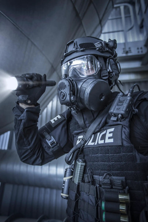 Officer in tactical gear using ProTac HL 5-X 3500 Lumen Multi Fuel Tactical Flashlight With Rechargeable Batteries and USB Cable.