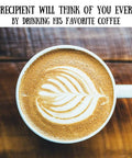 Latte with leaf art in ceramic mug on wooden table, text reads "Your recipient will think of you every day by drinking his favorite coffee"