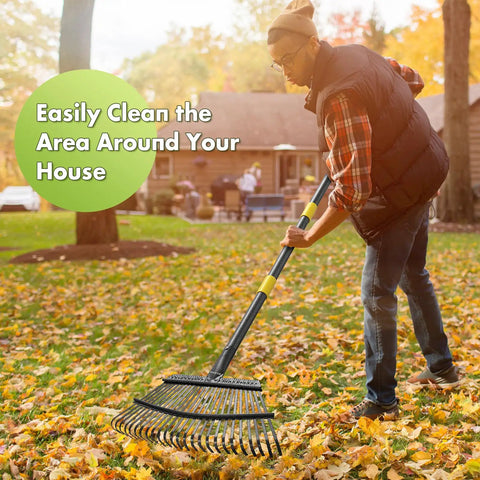 A person using a Heavy Duty Metal Leaf Rake With Adjustable 79 Inch Handle And 18 Inch Wide Head Featuring 25 Sturdy Tines for lawn cleanup.