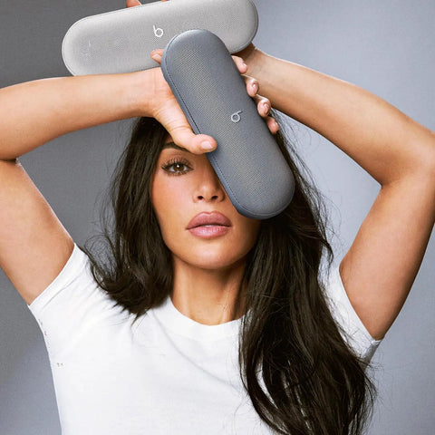 Person holding two models of Pill Wireless Bluetooth Speaker And Portable USB C Charger With All Day Battery Life IP67 Water Resistant