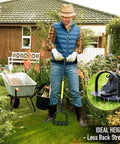 Person using 36 Inch Spike Lawn Aerator Tool With Longer Spikes, Preassembled Manual Grass Aerator for Lawn Aeration next to a wheelbarrow.