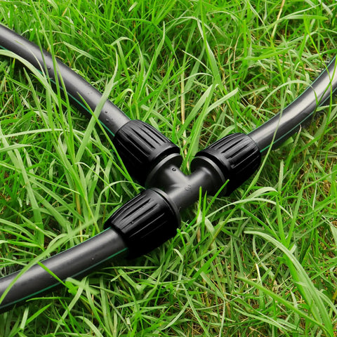 10 Pack Half Inch Drip Irrigation Barbed Tee Connectors With Locked Nut Anti Drop attached to tubing on grass