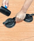 Person using Floor Gap Fixer Tool For Laminate And Floating Floors With Suction Cup And Mallet on wooden floor