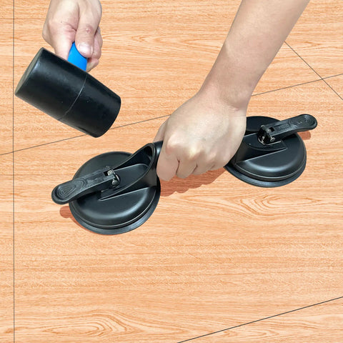 Person using Floor Gap Fixer Tool For Laminate And Floating Floors With Suction Cup And Mallet on wooden floor