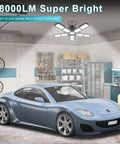 Modern garage with a blue sports car under Ultra Bright 4 Pack 180W Led Garage Lights 36000LM With E26 E27 Base Deformable