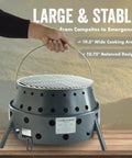Hand holding 2nd Gen Collapsible Grill And Stove Portable Camping Cooker For Charcoal Or Wood, showcasing wide cooking surface.