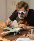 Man using Hands Free LED Magnifier Glasses with 14 Interchangeable Lenses 3X to 15X for model airplane details