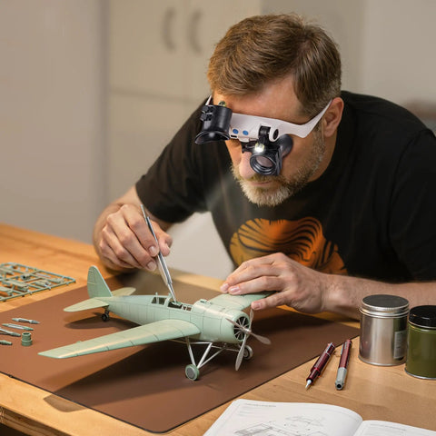 Man using Hands Free LED Magnifier Glasses with 14 Interchangeable Lenses 3X to 15X for model airplane details