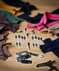 24-Piece Black Universal Zipper Slider Replacement Kit For Instant Fixes On Jackets, Bags And More, displayed with various zippers