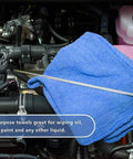 Person using Blue 12x14 Inch Shop Towels on car engine, 100 percent cotton, ideal for garage use as shown on packaging.