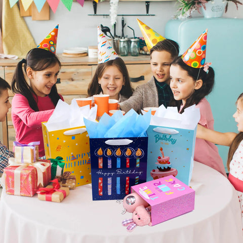 Children enjoying a party with Eight Pack Birthday Gift Bags With Ribbon Handles And Tissue Paper on a table, assorted sizes visible.