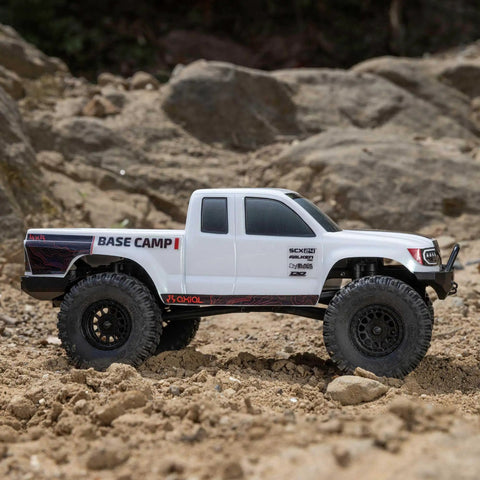SCX24 Base Camp 4x4 Rock Crawler Ready To Run RC Truck in white, 1/24 scale, on rocky terrain