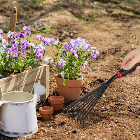 Nine Tines Metal Garden Hand Rake Set For Yard Lawn And Flower Beds Mini Cultivator Tools With Easy Grip Handle used for soil loosening near flowers.
