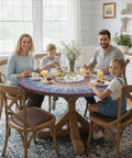 Family dining with Boho Vinyl fitted round tablecloth for 45 to 54 inch tables in a cozy indoor setting.