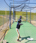Child practicing baseball in Heavy-Duty Backyard Batting Cage Net 55x12x12ft Weatherproof Polyester Construction for All Weather