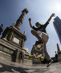 Skater performing a trick with Stimulus 70mm 86A Freeride Longboard Wheels Yellow Set of 4 in urban setting.