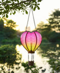 Heart Shaped Solar Lantern For Outdoor Decor Bright Hanging Light With Flickering Flame Garden Party Accent That Starts The Night Right Ideal For Valentines Day Anniversary Wedding Mothers Day And Backyard Lit Vibe, hanging in a garden during sunset.