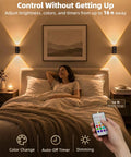 Sleek Wireless Motion Sensor Wall Light Rechargeable LED Sconce With Peels Off Paper Mount illuminating a cozy bedroom with remote control.