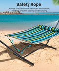 Two Person Quilted Outdoor Hammock With Stand Detachable Pillow And Bamboo Spreaders Portable Hammock With Carrying Bag Heavy Duty Frame Perfect For Yard Patio Or Outdoor Chill Dark Cyan set up on a beach