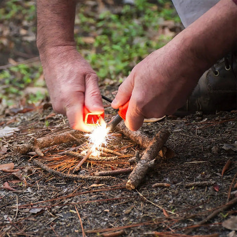 Person using StrikeForce Fire Starter With Tinder For Camping And Outdoor Survival Go To Gear Durable Flint Bar to ignite fire.