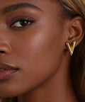 Chunky Gold Plated Earrings for Women, 18K Gold Plated Stainless Steel V Shape Heart Shell Studs shown on ear, trendy and hypoallergenic