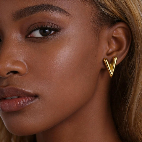 Chunky Gold Plated Earrings for Women, 18K Gold Plated Stainless Steel V Shape Heart Shell Studs shown on ear, trendy and hypoallergenic