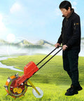 Person using Walk Behind Manual Seeder With Sixteen Precise Nozzles For Row Crops And Gardens, Durable Steel Frame, in field