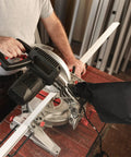 Universal Heavy Duty Tough As Nails Dust Collection Bag For Miter Saw And Table Saw Featuring Steel Reinforced Ash Outlet Fits Like A Glove black bag attached to miter saw collecting dust.