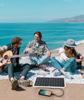 15W Flexible Waterproof Solar Panel USB C Charger with Micro USB and Barrel Port on beach powering a phone during picnic
