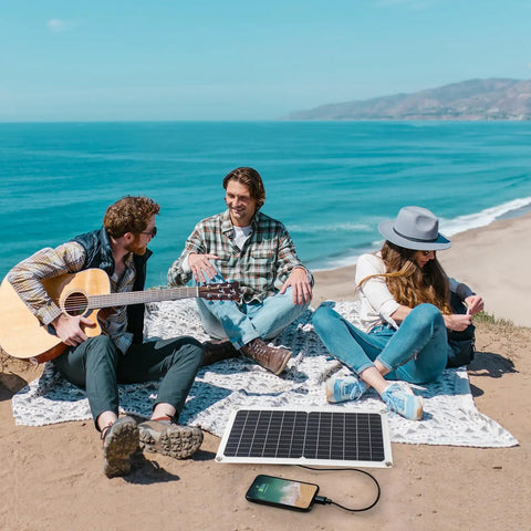 15W Flexible Waterproof Solar Panel USB C Charger with Micro USB and Barrel Port on beach powering a phone during picnic