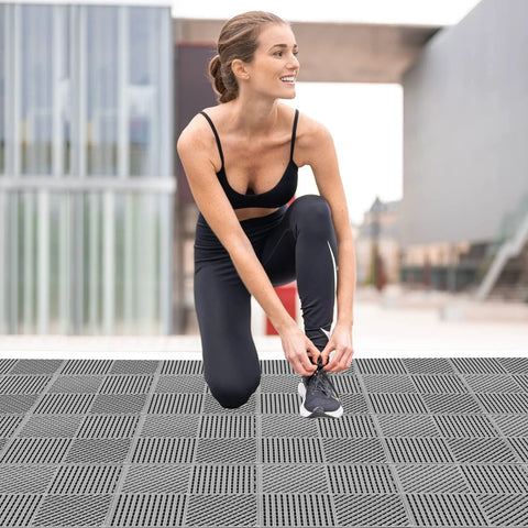 Woman tying shoes on Interlocking Drainage Floor Tiles No Slip With Drain Holes For Pool Bathroom Shower Patio Boat And Pet Areas 12 Inch