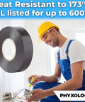 Black electrical tape roll (PHYXOLOGY) with paper core; worker in yellow hard hat and blue coveralls in background.