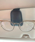 Hella Secure Magnetic Leather Car Visor Sunglasses Holder Stays Put With No Sweat Holds Eyeglasses Firmly And Keeps Tickets Organized During Daily Rides Super Convenient, featuring clear glasses held by leather clip.