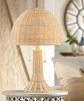 Bohemian Rustic 22 Inch LED Table Lamp With Natural Rattan Shade And Brass Gold Finish on nightstand in cozy bedroom