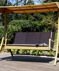 Outdoor canopy swing bench with cushion on wooden deck in garden setting