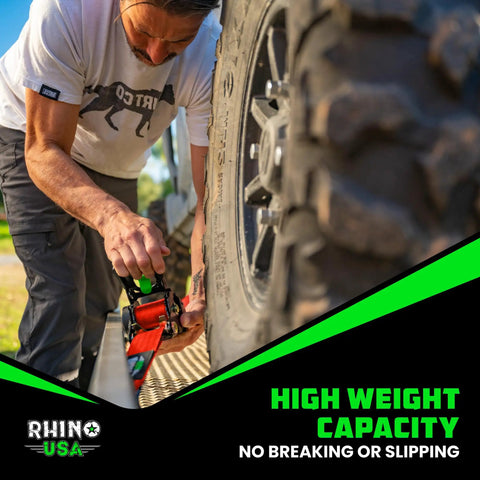 Kickass Retractable Ratchet Straps 2-Pack Cam Lock Tie Down 2 In X 10 Ft 3300 Lb being secured to a tire for safe transport.