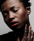 Person wearing Experience Plus High Fidelity Earplugs For Musicians, DJs And Nightlife, 18dB noise reduction, black color, close-up view.