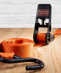 Top Shelf Ratchet Tie Down Straps 1 Inch By 10 Feet 4 Pack with orange strap and black ratchet mechanism on wooden surface.