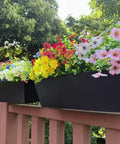 Set Of Four Heavy Duty Metal Railing Planters, 16 Inch Rectangular Window Boxes with vibrant flowers on a railing.
