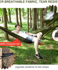 Man relaxing in Go To Camping Hammock With Rain Fly Tarp And Built In Mosquito Net, Tree Straps Included, outdoor forest setting
