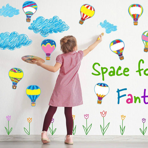 Child decorating wall with Totally Colorful Hot Air Balloon Cutouts Set With 54 Paper Shapes And 60 Glue Dots