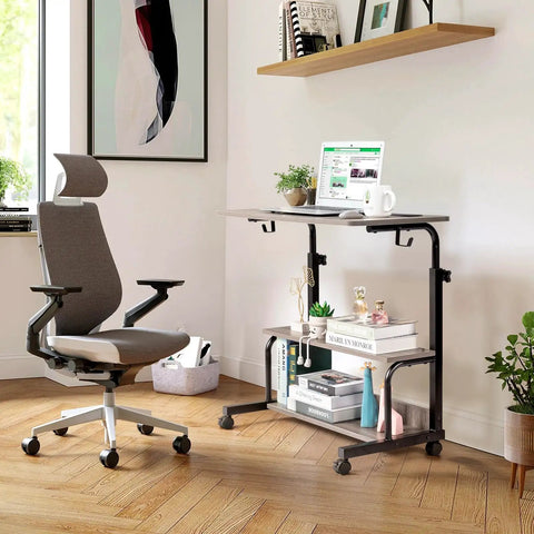 Unwind And Handle Daily Grind At This Grey Oak Rolling Standing Desk With Height Adjustable Top Smooth Gliding Wheels Grab And Go Mobility Side Hooks And Roomy Storage Shelves For Your Home Office Setup, featuring laptop on rolling cart with plants.