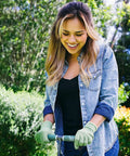 Person using Beefy Spike Lawn Aerator Tool With 37 Inch Handle, Manual Grass Aerator And Dethatcher Rake, in a garden.