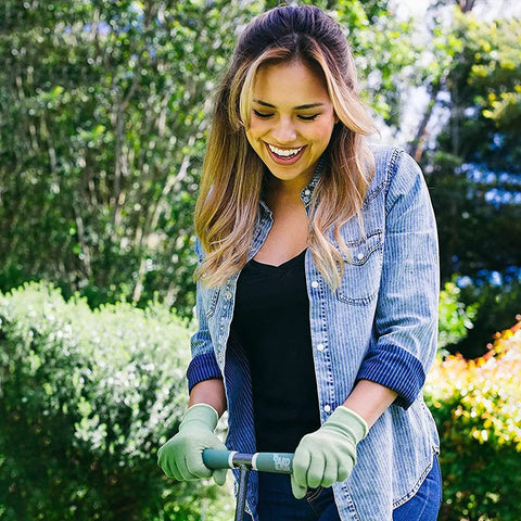 Person using Beefy Spike Lawn Aerator Tool With 37 Inch Handle, Manual Grass Aerator And Dethatcher Rake, in a garden.