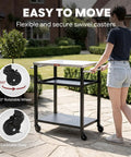 Person moving Three Tier Outdoor Grill Cart With Rolling Pizza Oven Table And Stainless Steel Top 26.6 By 16.1 Inches Heavy Duty Steel Stand For Pizza Ovens And Griddles Outdoor Bar Cart With S Hooks For Patio Parties Deck Dining And Camping on patio with swivel casters